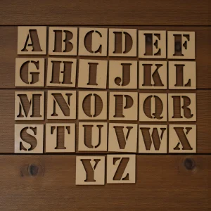 alphabet stencils laid out with crayons and pens for creative tracing activity