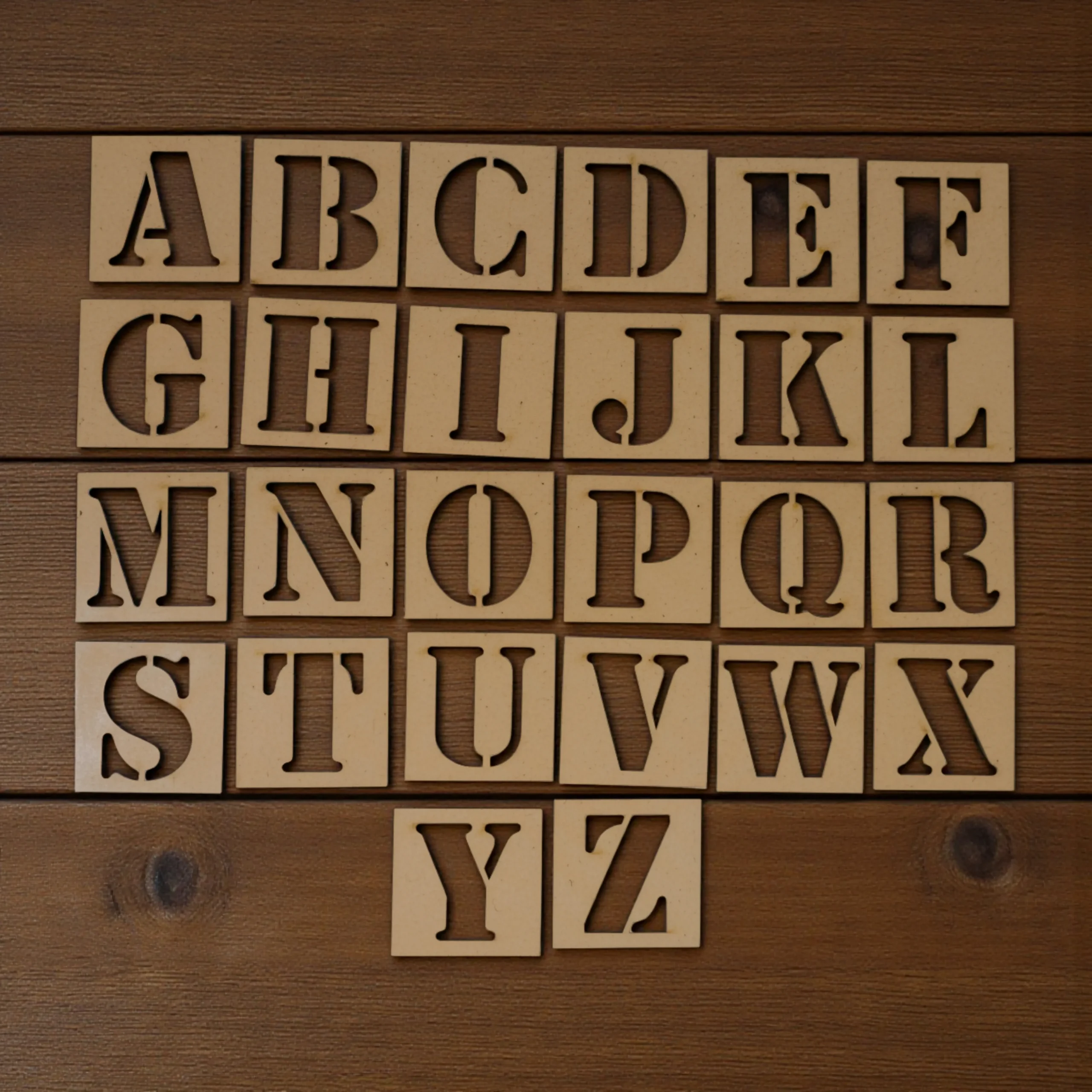 alphabet stencils laid out with crayons and pens for creative tracing activity