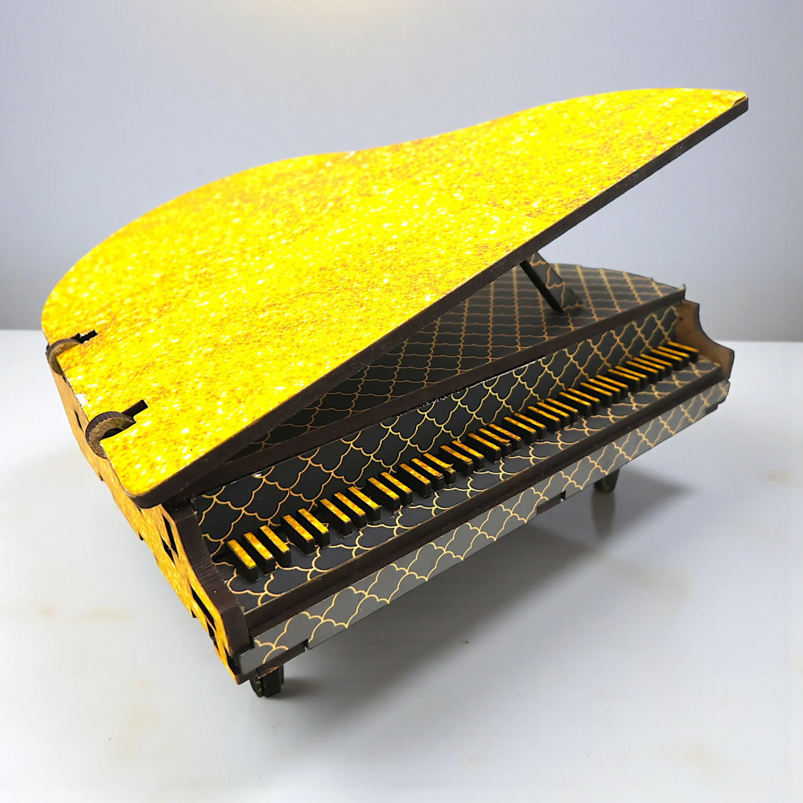 close up of the miniature wooden piano décor piece showing crafted keys and smooth finish